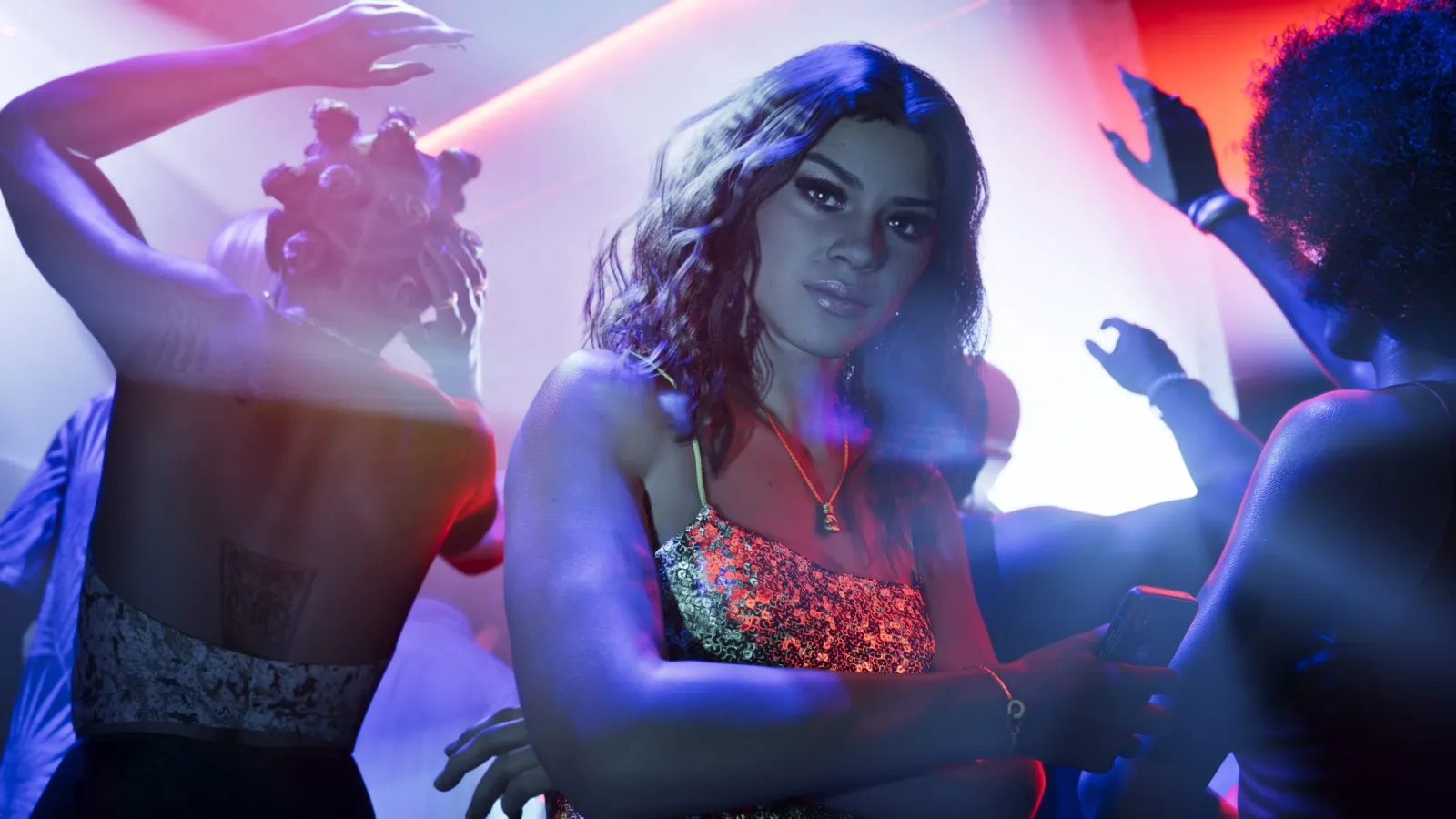 Lucia from GTA 6 lit by blue and red neon inside a Vice City club at night